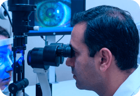 Scientist examining samples through a microscope in a modern lab setting.