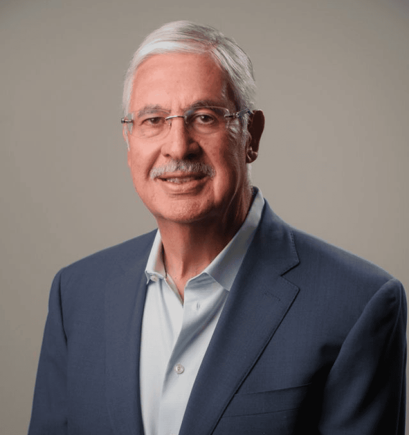 Senior professional in research management wearing a suit and glasses.