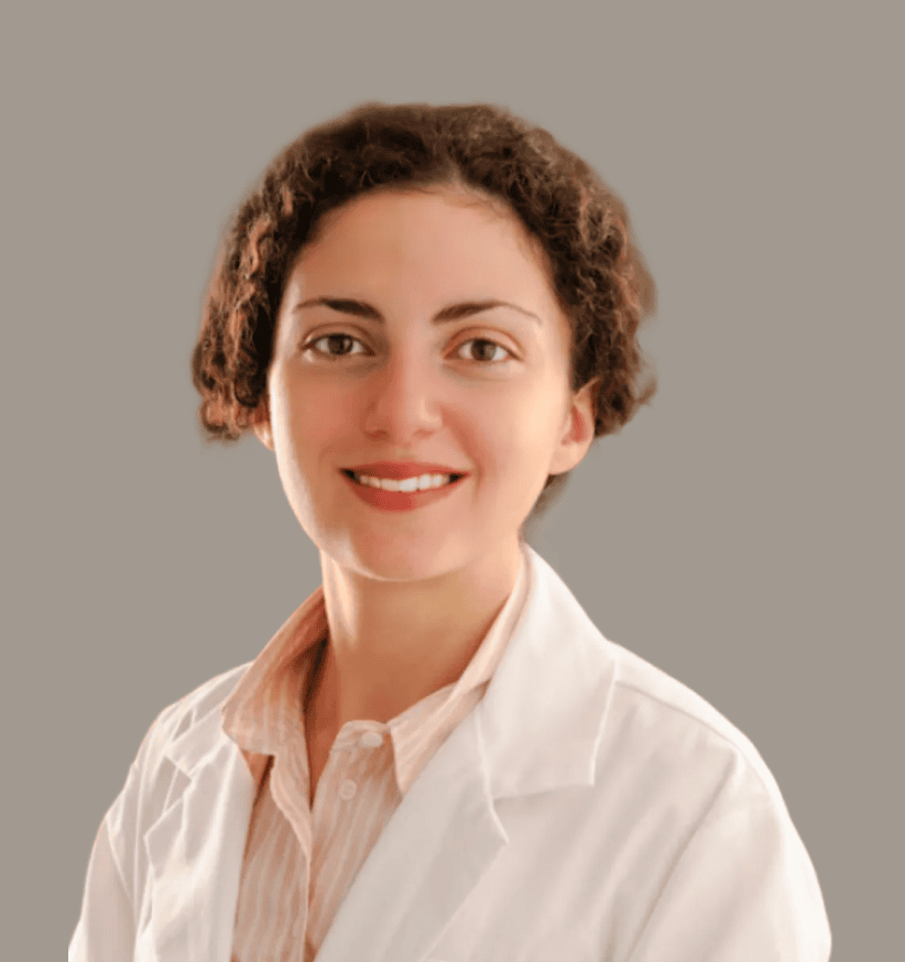 Female research professional in a white lab coat smiling, representing clinical research expertise.