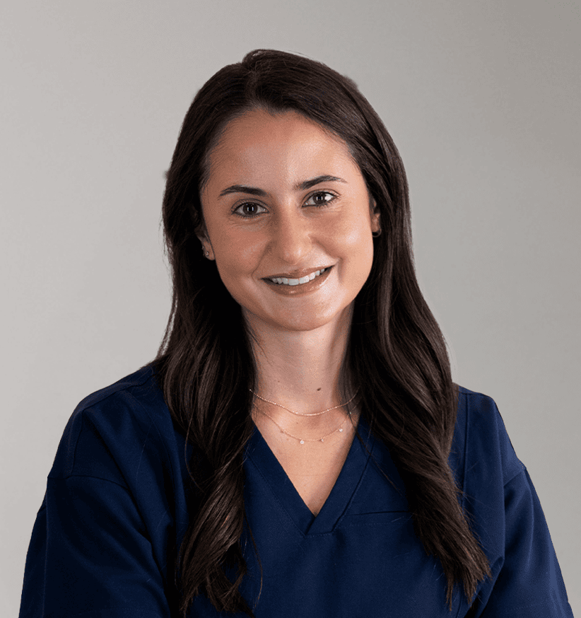 Clinical research professional smiling in navy scrubs, representing expertise in global research man.